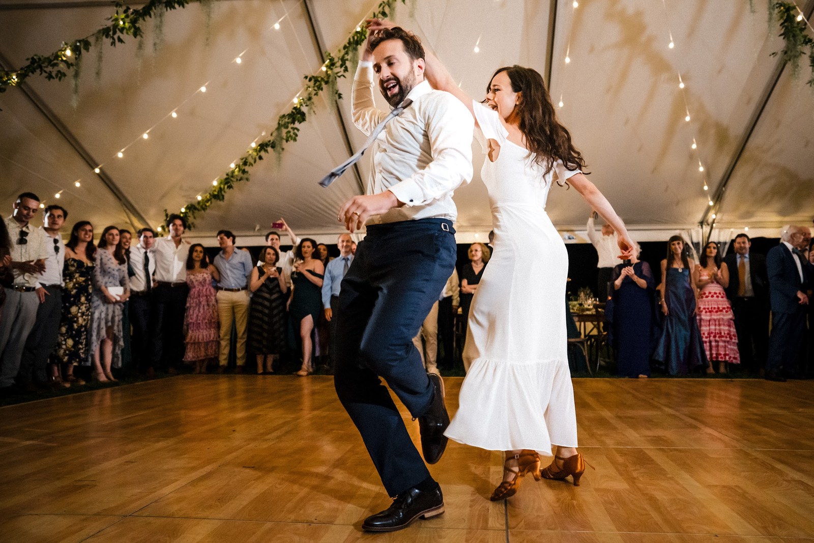 Couple dancing energetically at a tented Philadelphia area wedding reception